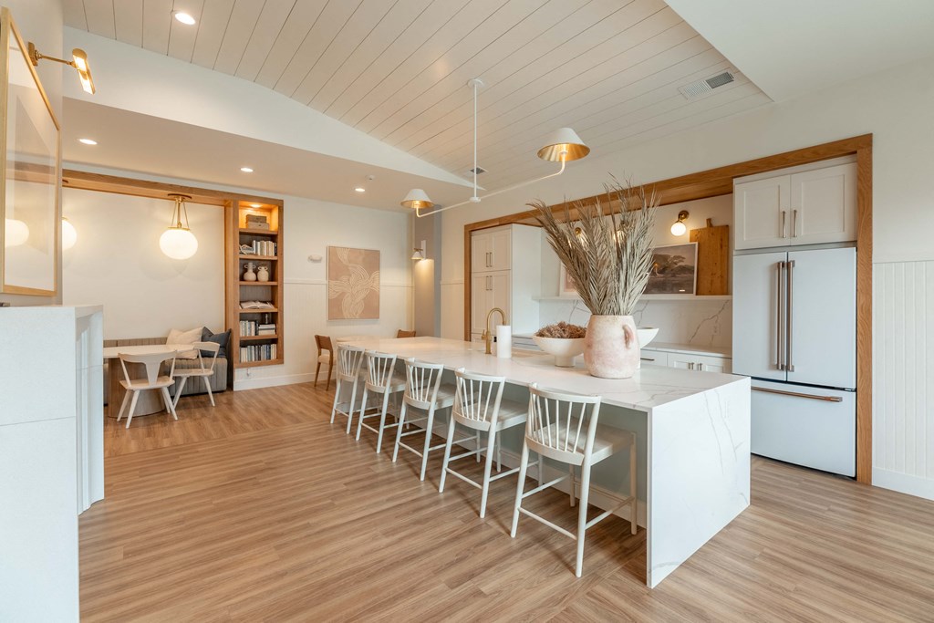 a large kitchen with a white counter top and a dining table
