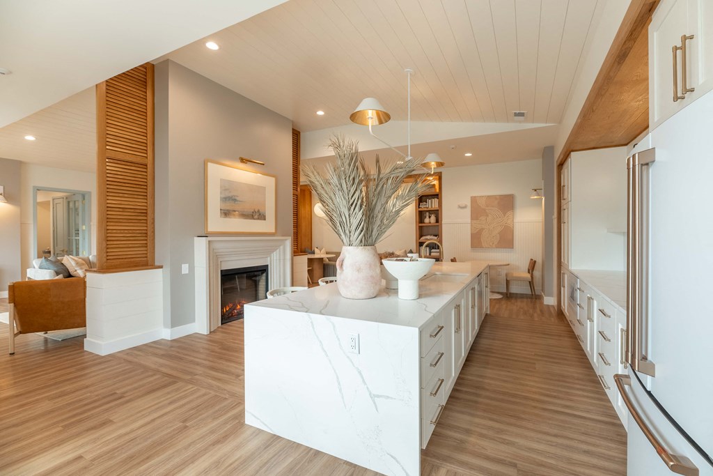 a kitchen with a white island and a fireplace