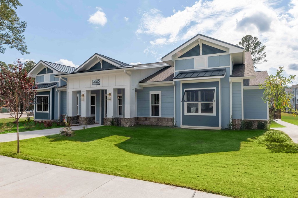 a blue house with a lawn in front of it