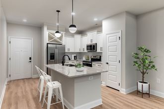 a kitchen with white cabinets and a marble counter top