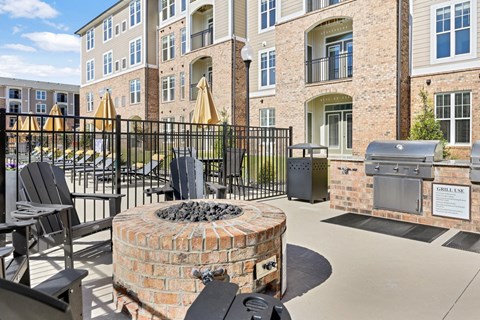 A patio area with a fire pit and chairs.