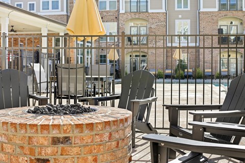 A patio with chairs and a fire pit.
