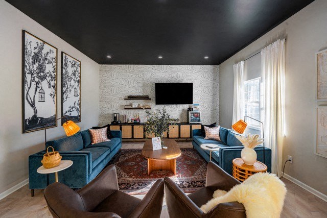 a living room with blue furniture and a black ceiling