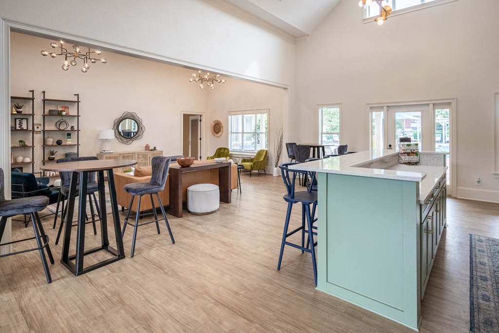 a living room with a bar and a kitchen with stools