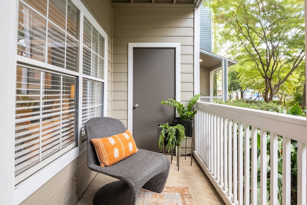 a porch with a wicker chair and a door to a house