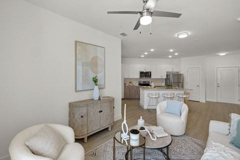 a living room and kitchen with a ceiling fan