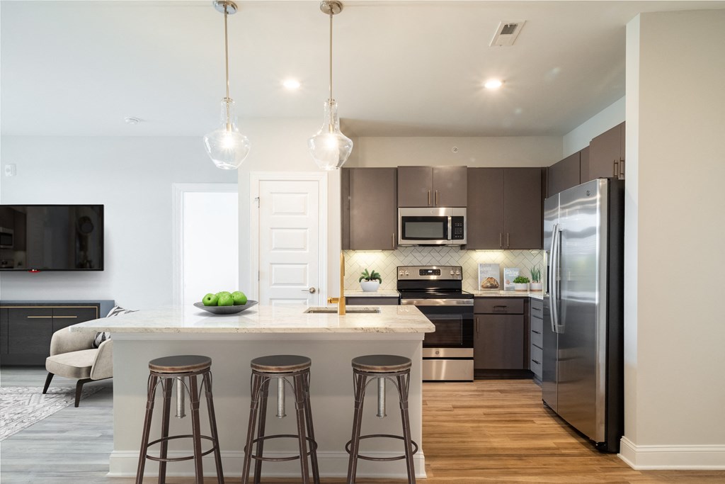 a kitchen with a large center island with three stools