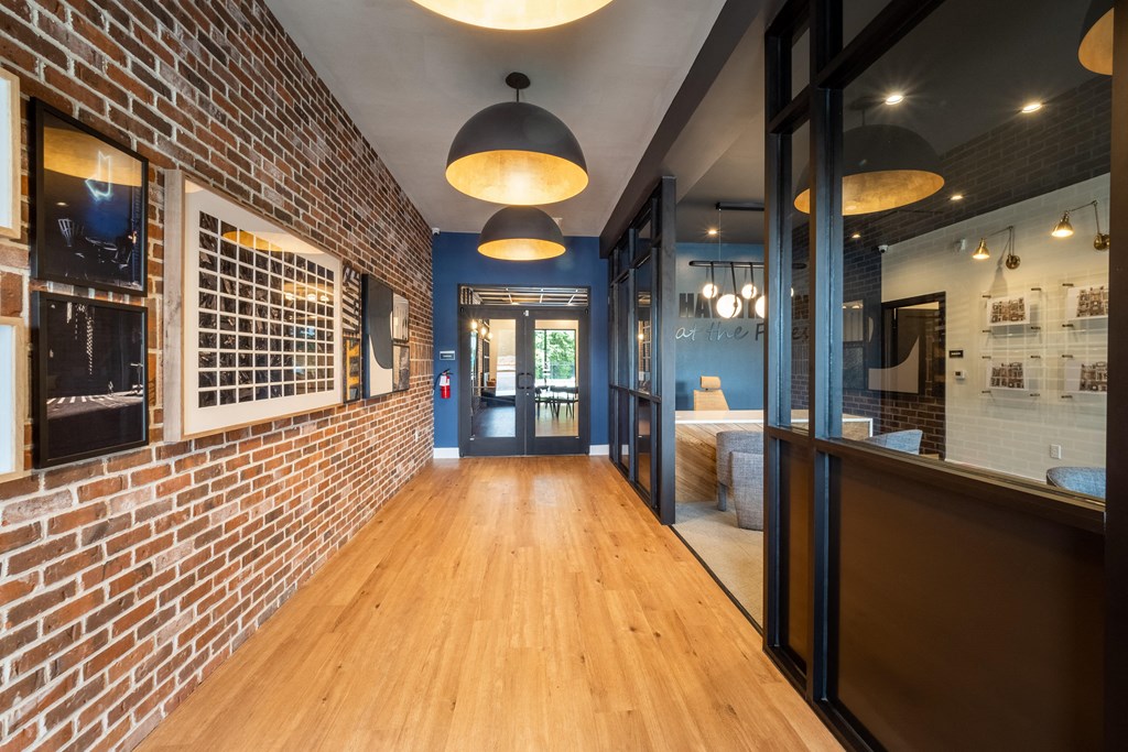 a long corridor with exposed brick walls and wood floors