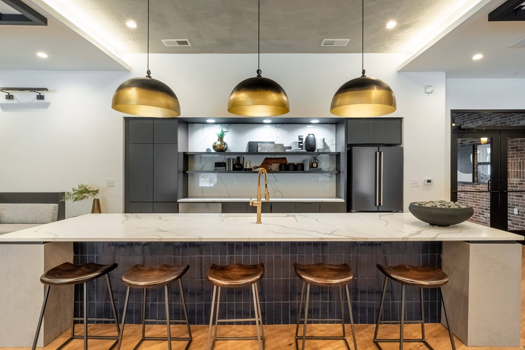 a kitchen with a large island with four stools in front of it