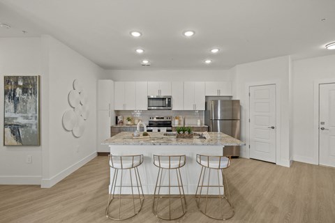 a kitchen with a marble counter top and three bar stools