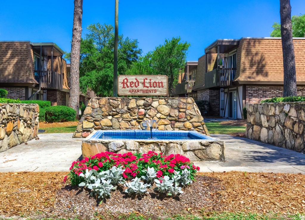 a fountain with flowers in front of a hotel sign