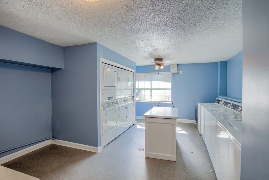 a blue and white kitchen with blue walls and white appliances