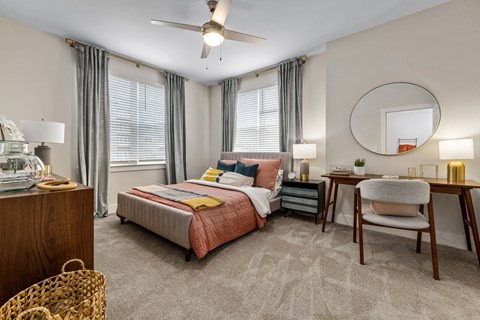 A bedroom with a bed, desk, and chair.