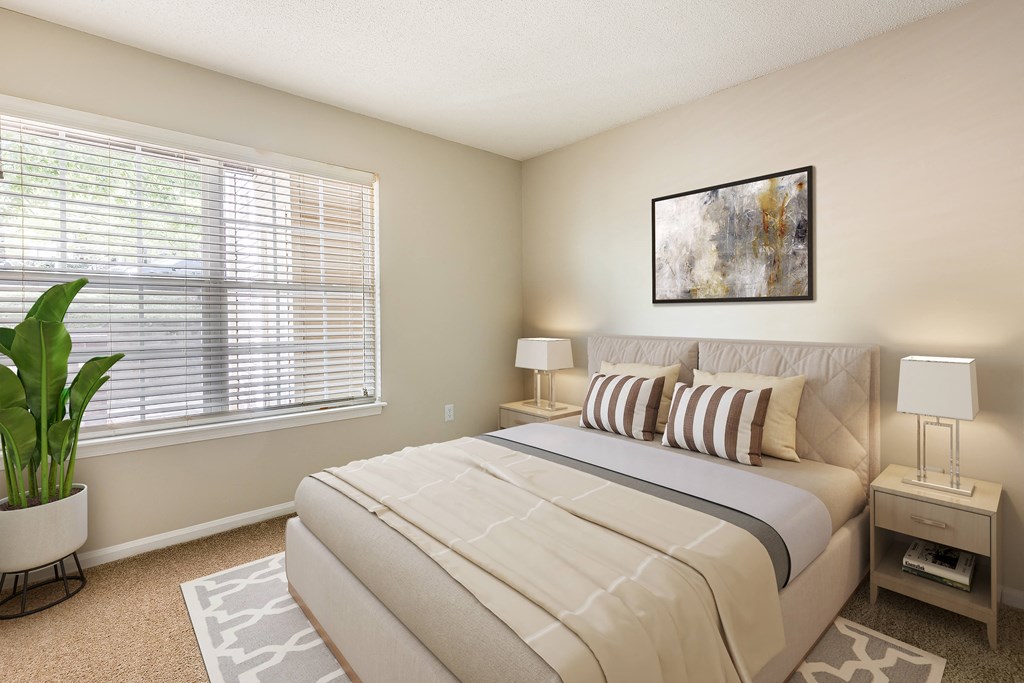 a bedroom with a large window and a large potted plant