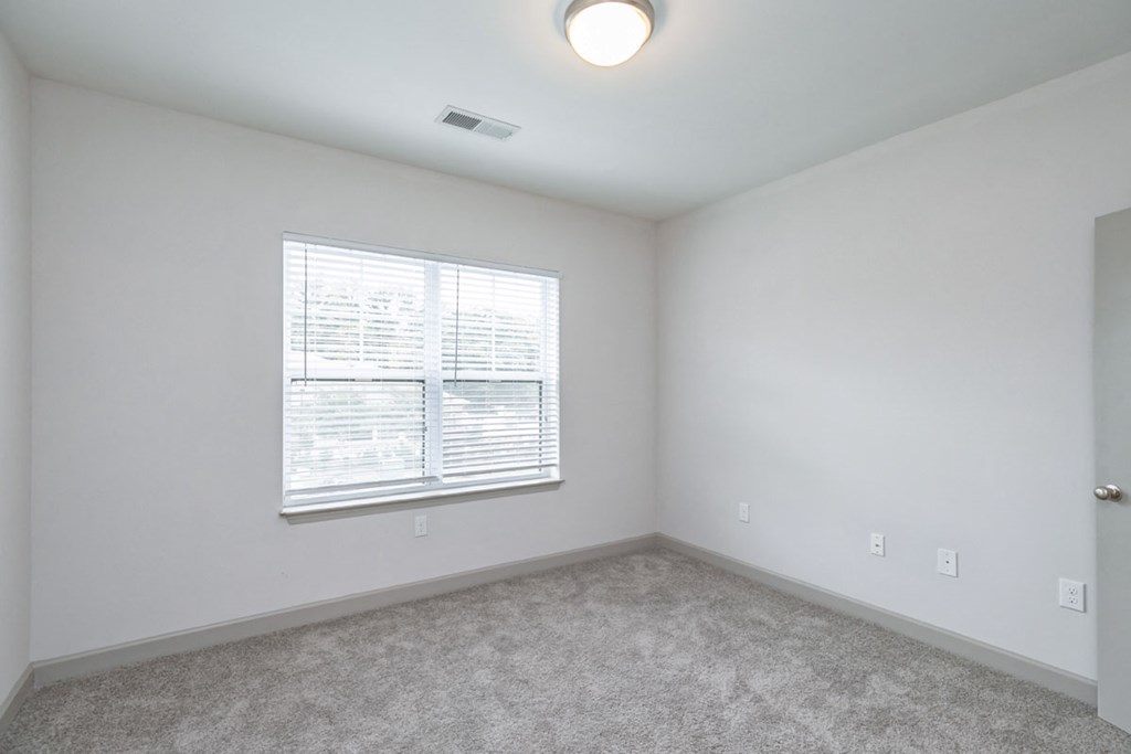 the living room of an empty home with a large window