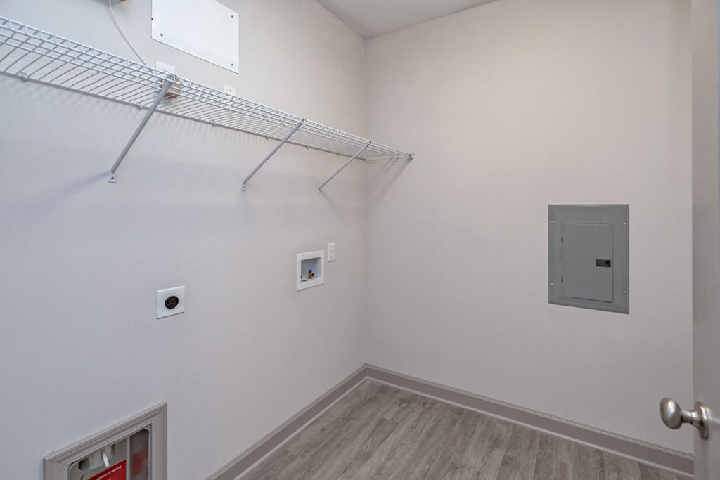 a white room with a shelf on the wall and a door