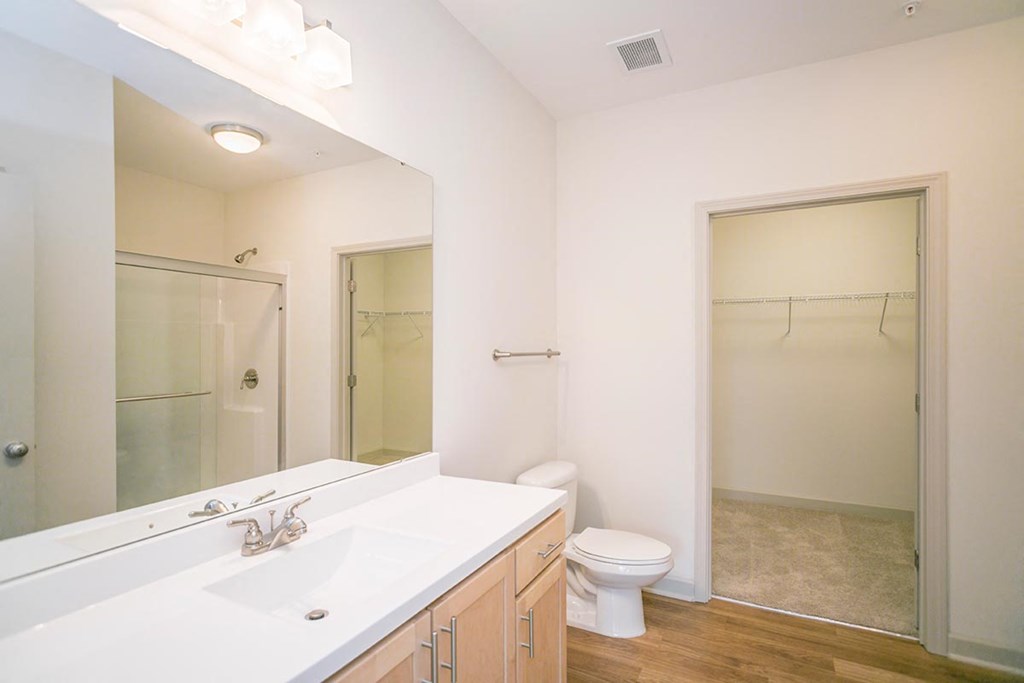a bathroom with a large mirror and a toilet and a shower