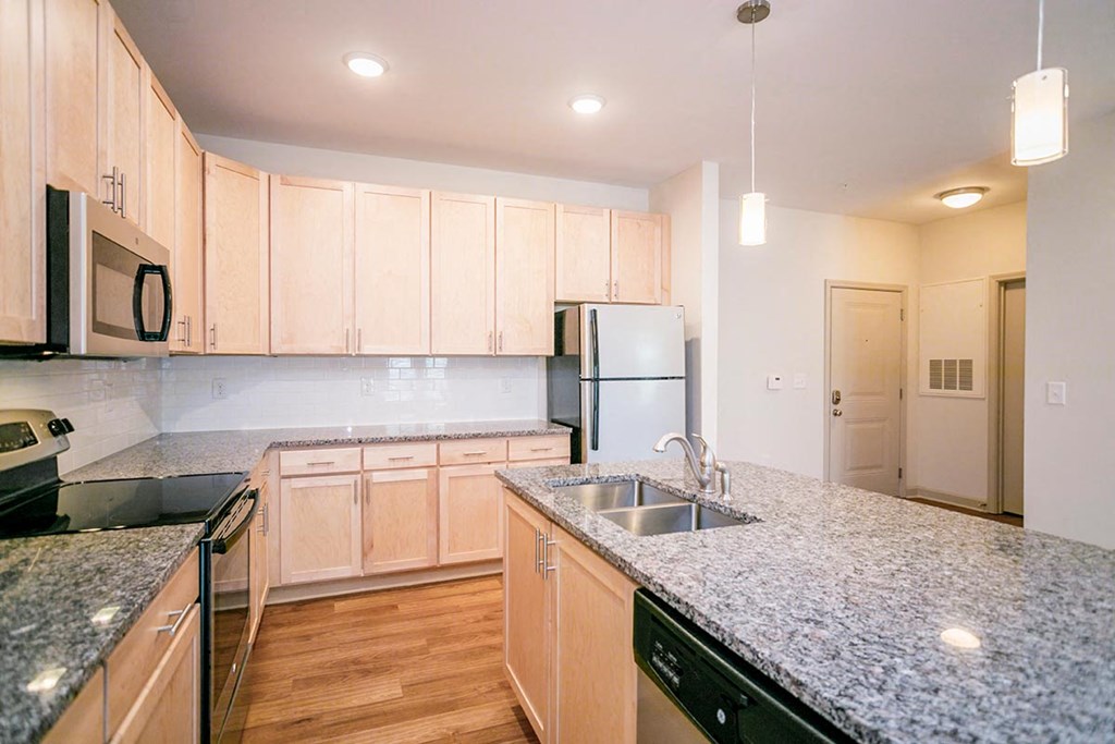 a kitchen with granite counter tops and wooden cabinets