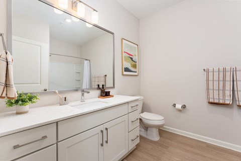 A bathroom with a white counter top and a toilet at Evolve Holly Ridge Apartments in Holly Ridge, NC.