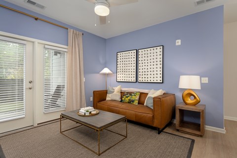 A living room with a brown couch and a coffee table.