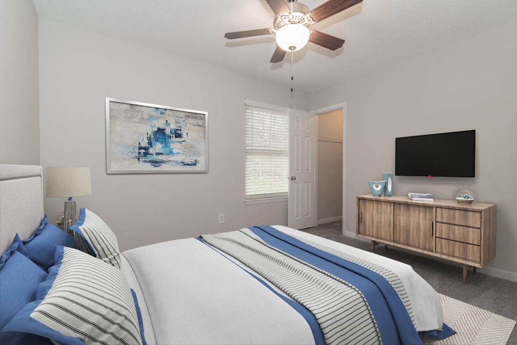 a bedroom with a bed and a ceiling fan