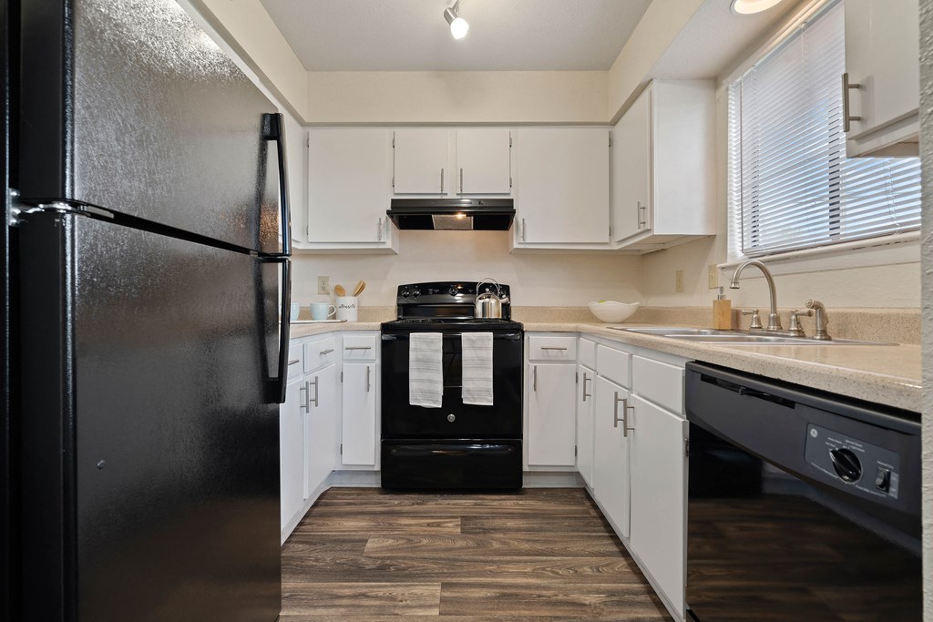 a kitchen with white cabinets and black appliances