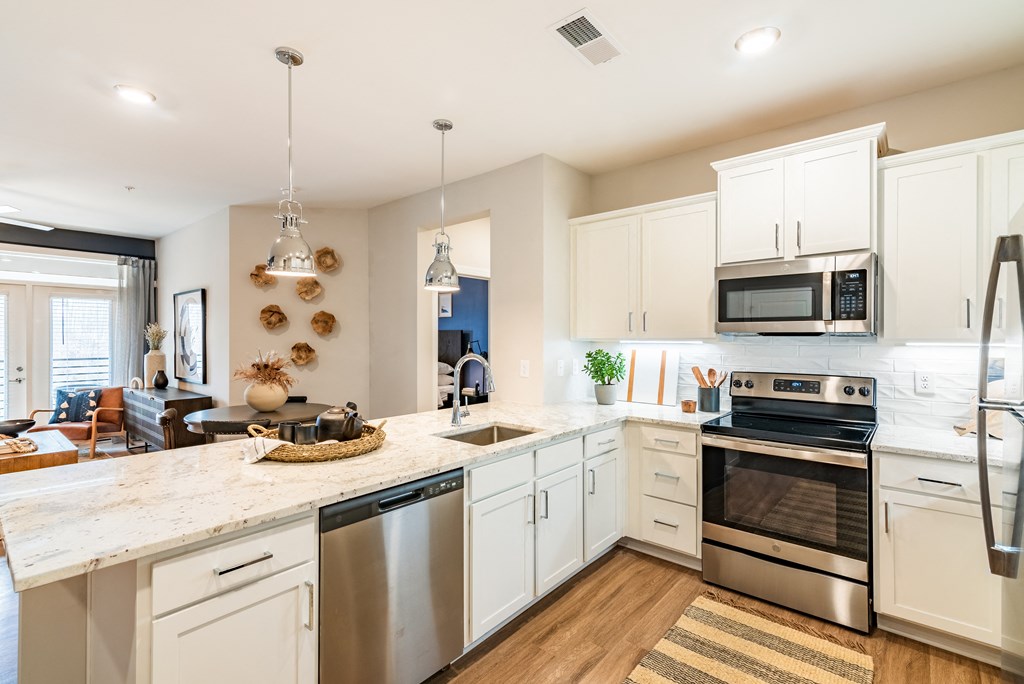 a large kitchen with stainless steel appliances and white cabinets