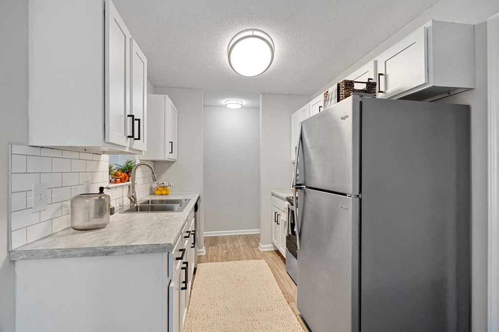 a renovated kitchen with stainless steel appliances and white cabinets