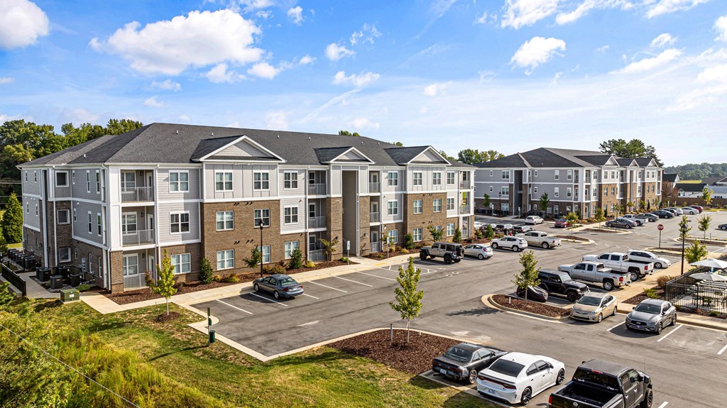 an aerial view of an apartment complex with cars parked in a parking lot