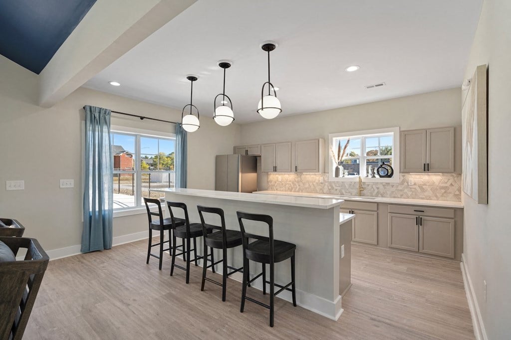a kitchen with a large island with bar stools