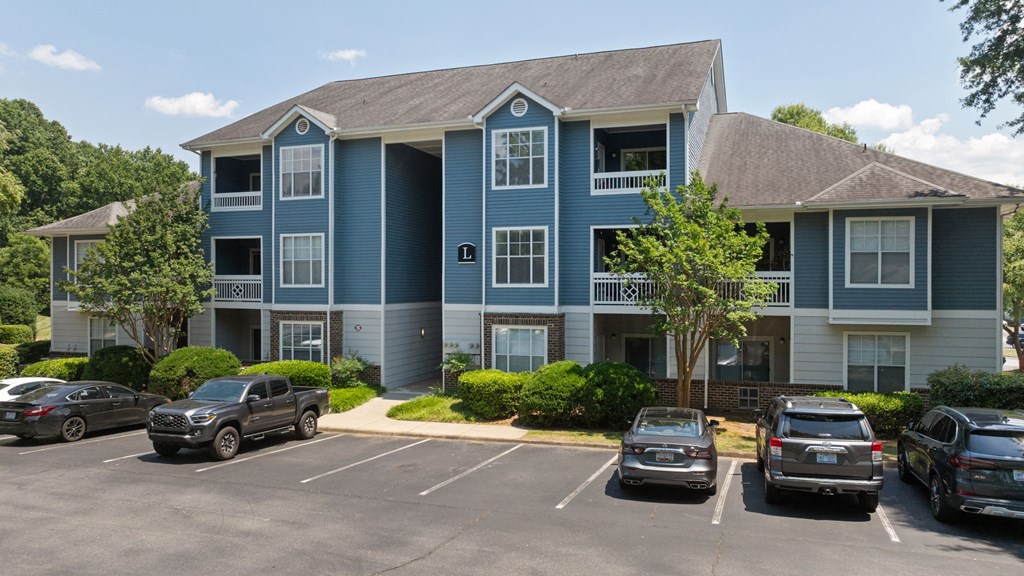 an apartment building with cars parked in front of it
