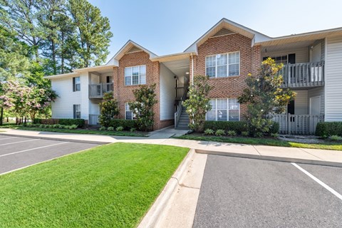 A row of townhouses with a paved driveway in front.