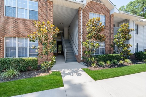 A brick building with a green lawn in front.