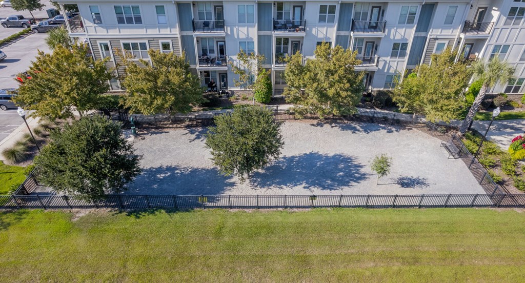an aerial view of a park with trees in front of an apartment building