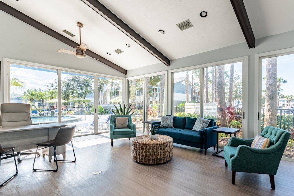 a living room with a couch chairs and a table with a chair and ottoman in