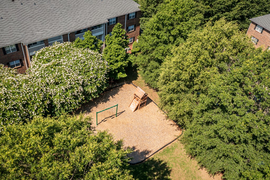 an aerial view of a backyard with a fire pit and trees