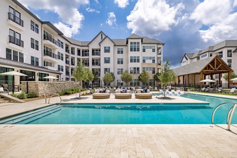 a swimming pool with an apartment building in the background