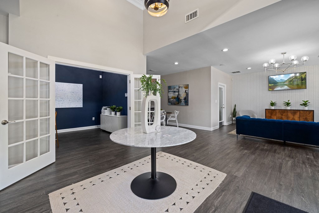 a living room with a round table and a blue couch