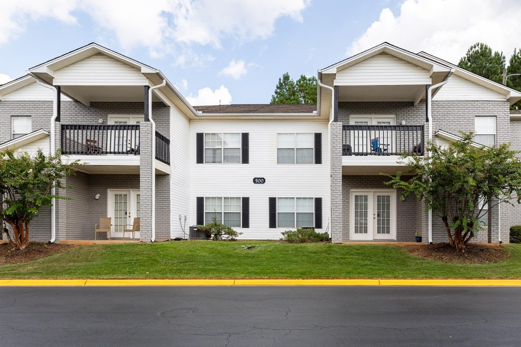 A two-story apartment building with a balcony on the second floor.