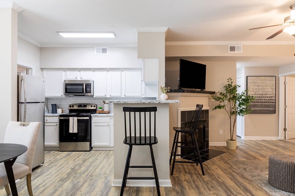an open kitchen and living room with a dining room table and chairs