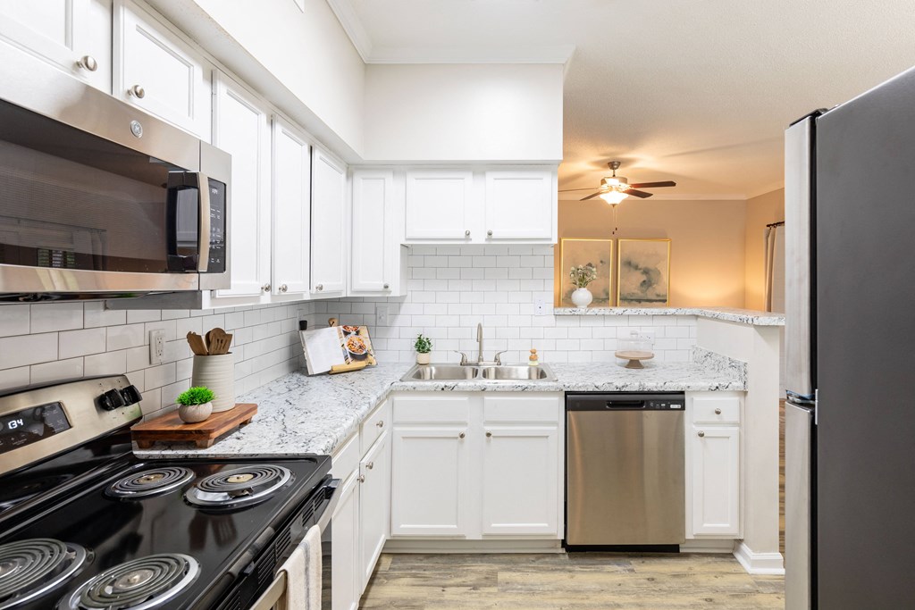 a kitchen with white cabinets and stainless steel appliances