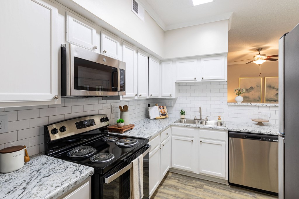 a kitchen with stainless steel appliances and marble counter tops