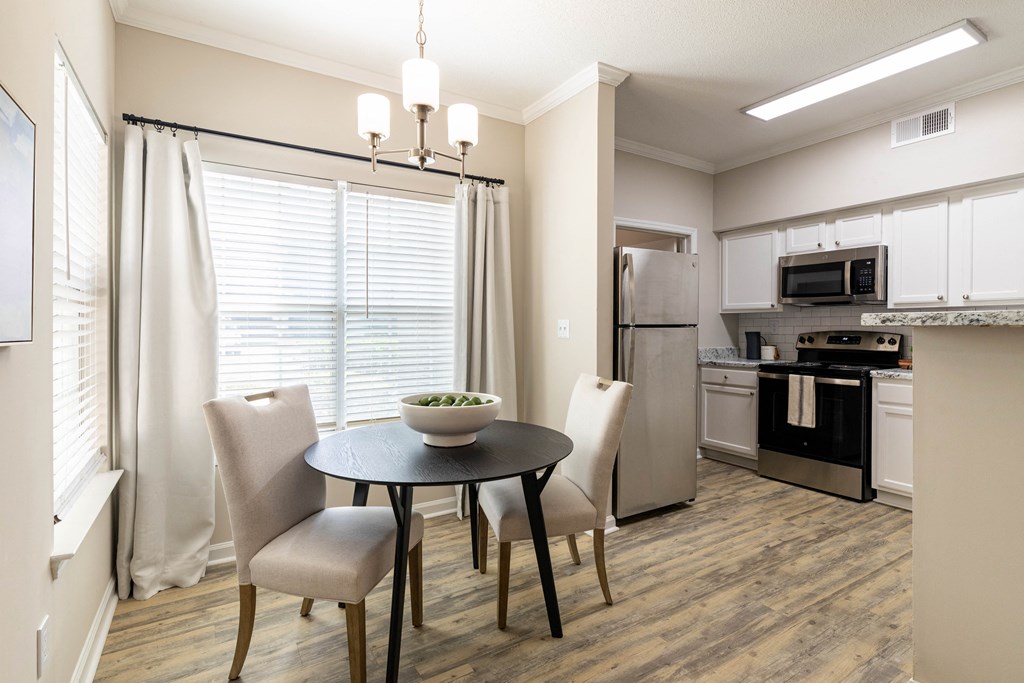 a kitchen and dining room with a table and chairs