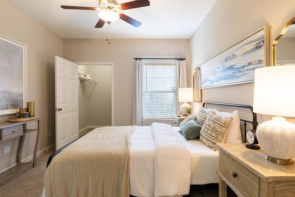 a bedroom with a large bed and a ceiling fan