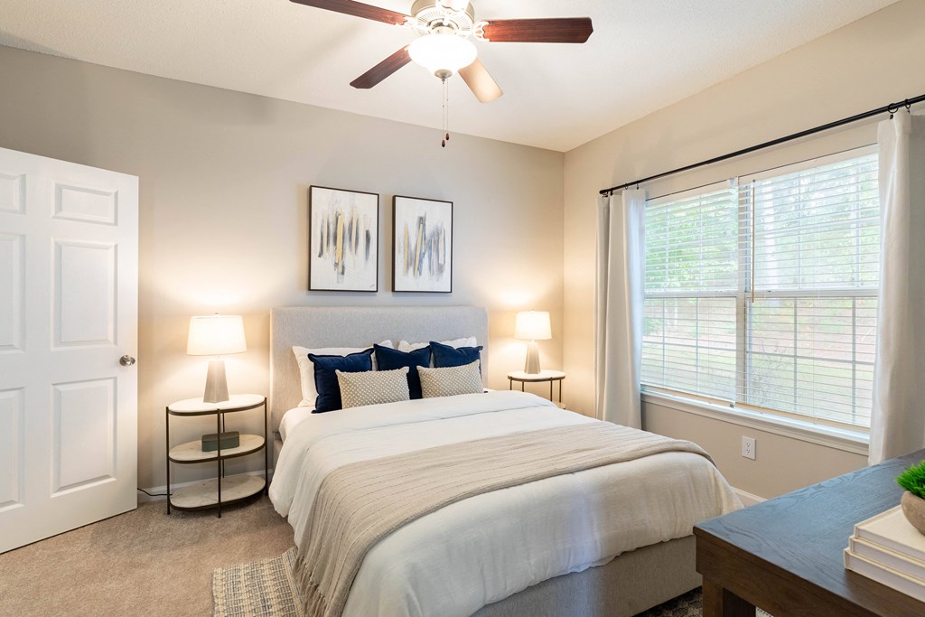 a bedroom with a large bed and a ceiling fan