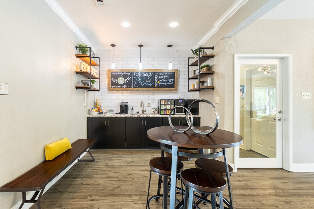 a kitchen and dining area with a table and four stools