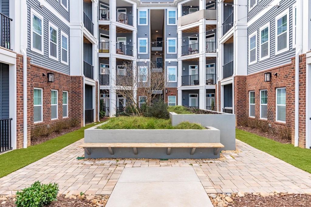 an outdoor area with a bench in front of an apartment building