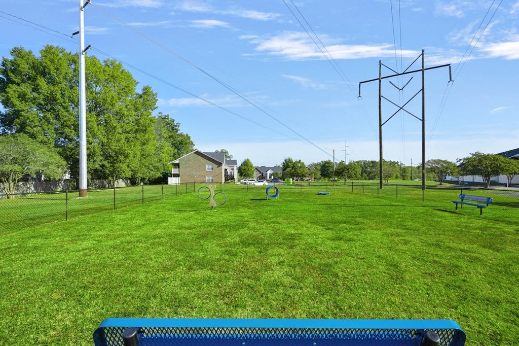 a park with a playground and benches in the grass