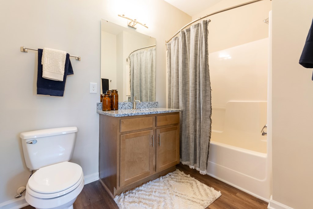 A white toilet sits next to a wooden cabinet in a bathroom.