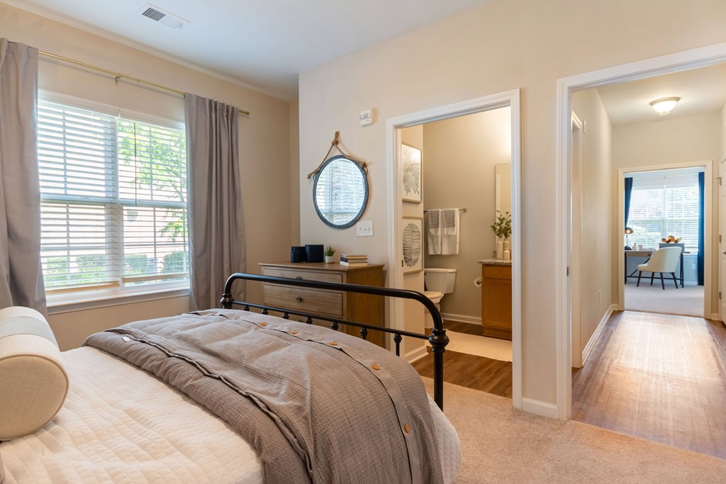 A bedroom with a large bed and a mirror on the wall.